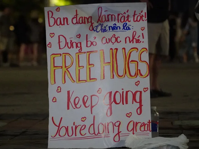 Các bạn trẻ Việt Nam với bảng "Free Hugs" đang hoạt động trên đường phố.