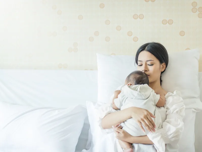 Bé gái vui vẻ ôm mẹ một cách trìu mến, minh họa lợi ích của Skinship trong việc xây dựng sự gắn kết bền chặt, tình cảm yêu thương và hỗ trợ tinh thần giữa mẹ và con.