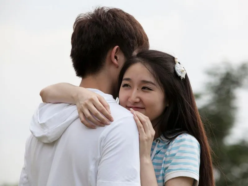 Cặp đôi đang ôm hôn, minh họa cách xin lỗi người yêu bằng cử chỉ thân mật và chân thành.