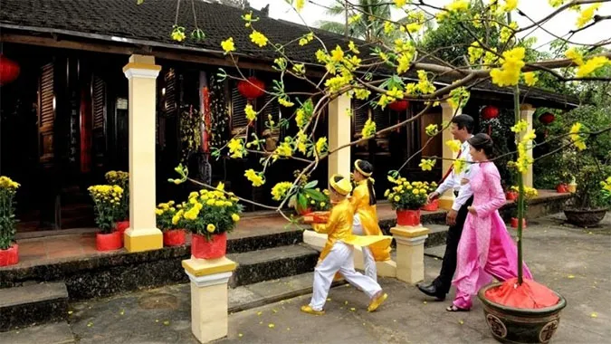 Gia đình Việt quây quần đón người xông đất, thể hiện sự tiếp nối tục xông đất trong đời sống hiện đại và niềm tin vào may mắn đầu năm.