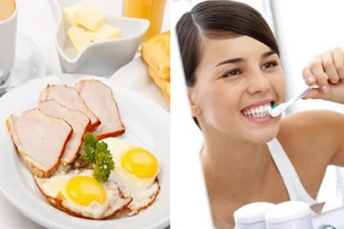 Cô gái đang đánh răng trước gương sau khi ăn.