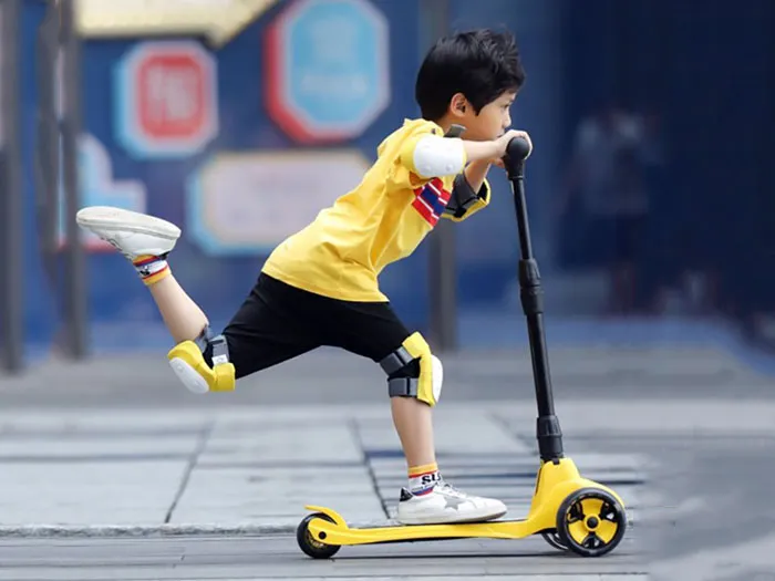 Bé trai chơi xe Scooter ngoài trời, phát triển kỹ năng giữ thăng bằng và vận động.