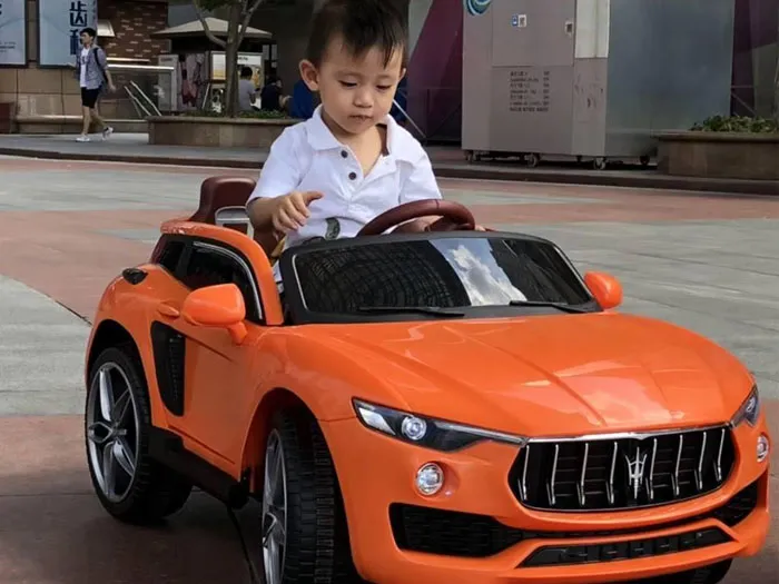 Xe ô tô điện trẻ em màu đỏ, mang lại trải nghiệm lái xe thú vị cho bé trai.