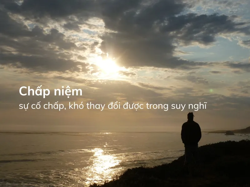 Người đang trầm tư suy nghĩ về khái niệm chấp niệm là gì và cách buông bỏ để tìm an yên.