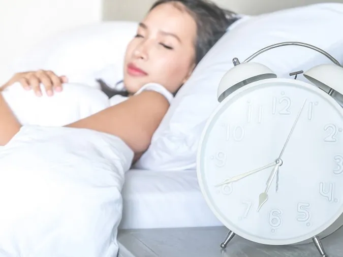 Người đang xoa đầu vì đau đầu, biểu hiện của việc ngủ quá nhiều và các vấn đề sức khỏe liên quan
