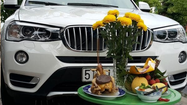 Bàn thờ cúng xe ô tô đầu năm mới với mâm ngũ quả và hương đèn.