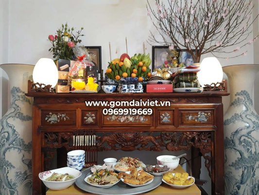 Bàn thờ gia tiên trang trọng với hoa tươi và lễ vật đầy đủ