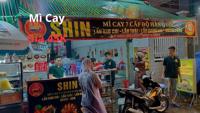 Bàn ăn đầy ắp các món mì cay xíu và đồ uống tại quán ăn ở Quận 4