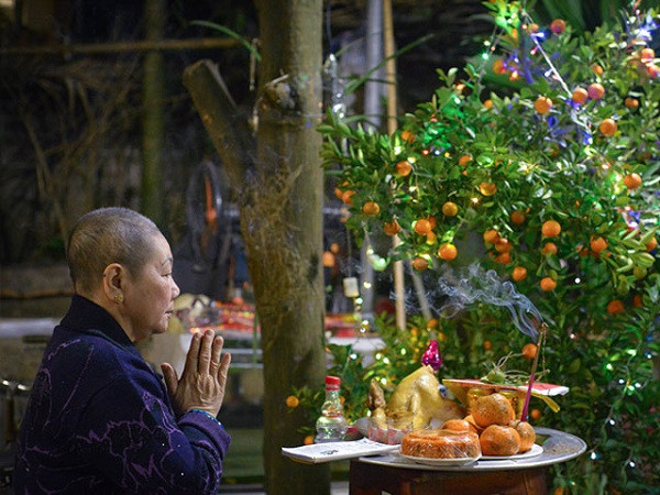 Người phụ nữ thành tâm dâng hương cúng ngoài trời trong đêm giao thừa
