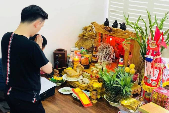 Người thân thắp hương cúng Thần Tài Thổ Địa trên bàn thờ
