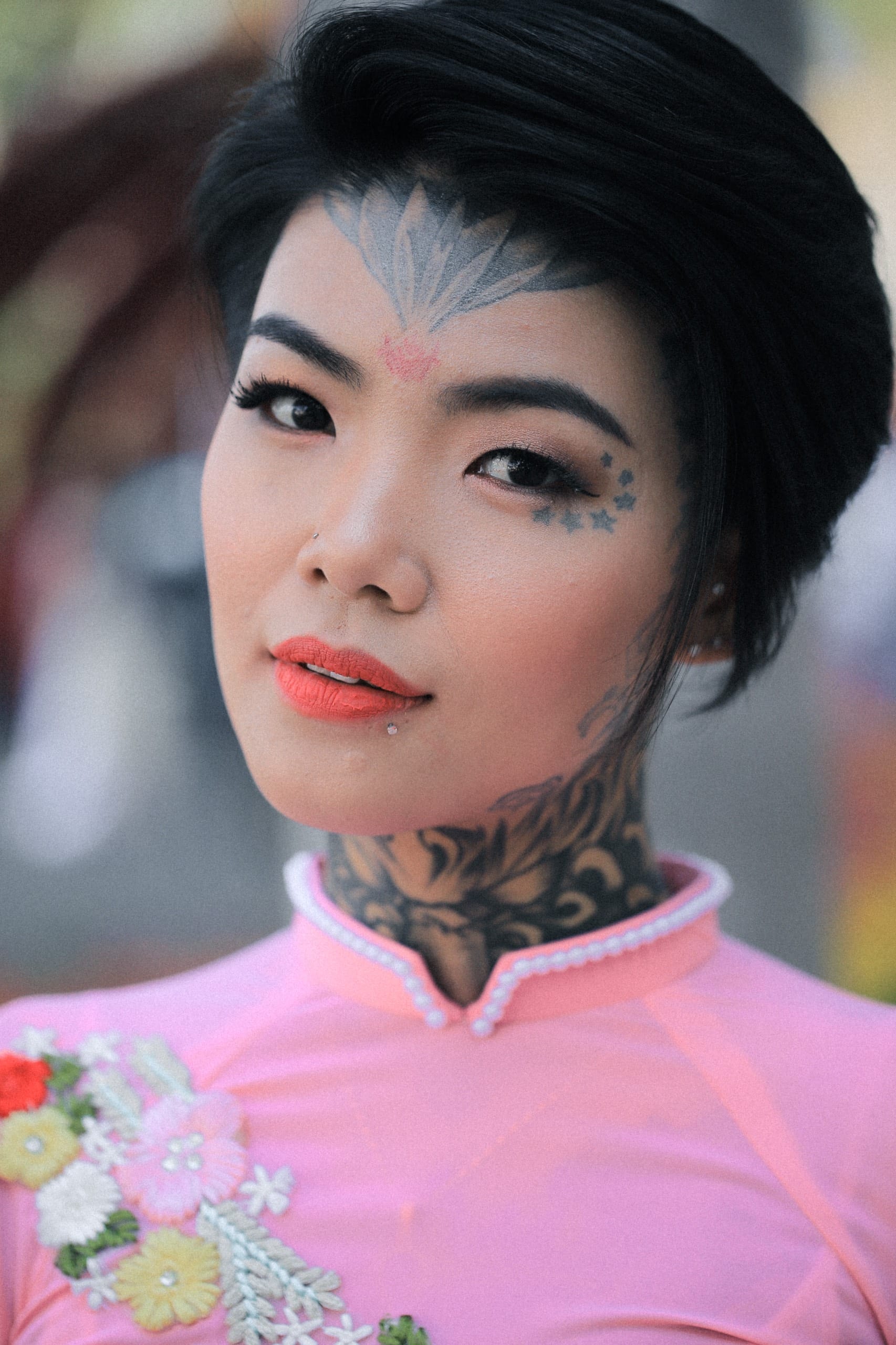 Phạm Thị Huỳnh Mai, cô gái xăm trổ, đứng giữa phố đèn lồng với bộ sườn xám đỏ, thể hiện sự tự tin và cá tính riêng