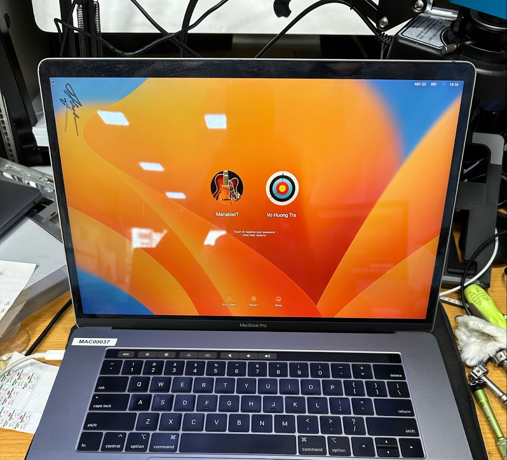 Kỹ thuật viên đang kiểm tra và sửa chữa mainboard Macbook tại trung tâm sửa chữa chuyên nghiệp