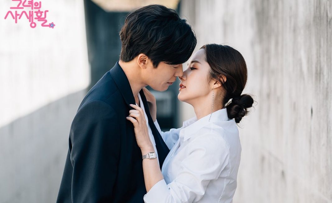 Cặp đôi đang skinship với hành động ôm chặt và tựa đầu vào nhau trên bãi biển